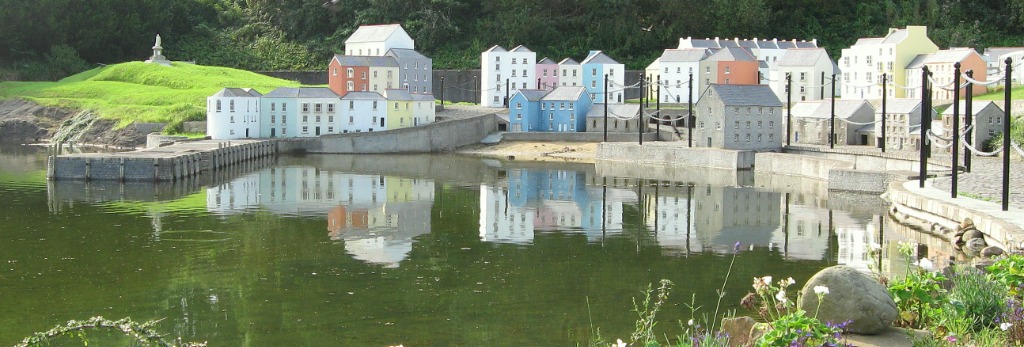 Miniature Georgian pastel fishermen's cottages, harbor quayside, and stone warehouses reflected in the harbor water